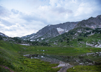 Fototapeta na wymiar panoramic view of the mountain lake with tourist tents a cloudy summer day. Adygea, Russia.