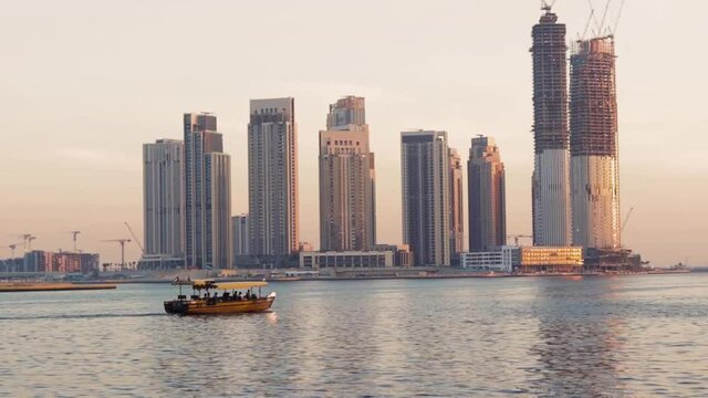 Dubai, UAE - 04.17.2021 Traditional Emirati boat called abra sailing trough creek in front of Dubai Creek Harbour. Outdoors
