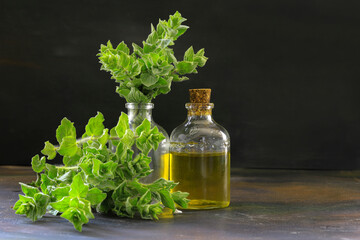 A bottle of thyme essential oil with fresh thyme leaves