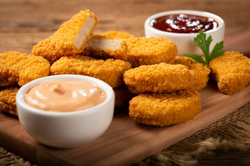 Fried chicken nuggets with ketchp and rose sauce.