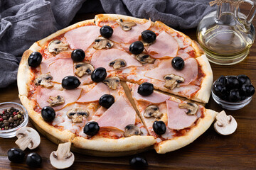 pizza and pizza ingredients. Olives, mushrooms and pizza on a dark background