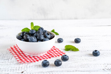 Juicy and fresh blueberries in a bowl on a rustic table. Concept for healthy summer harvest