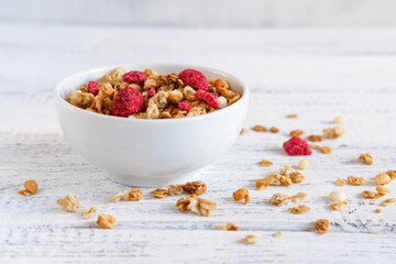 Bowl of homemade muesli with dried raspberries. Sprinkled muesli
