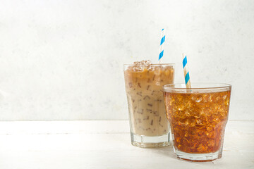 Set with different iced summer coffee drinks - espresso, frappe, latte, cappuccino, with whipped cream, syrup and crushed ice, in various glasses and mugs on white background copy space