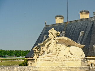 Obraz premium Sphynx guard sculpture, detail of castle of chantilly, france, selective focus with blurry building in the background 