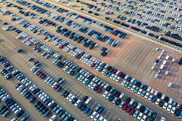 Aerial view of the dealership or customs terminal parking lot with a rows of new cars