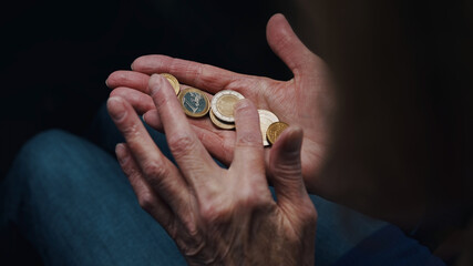 Wrinkled hands of elderly woman counting coins. Close up. High quality photo