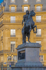 Paris, France - 03 28 2021: Vie of the Victories Square and statue of Louis XIV carrying his head in his hands at sunset
