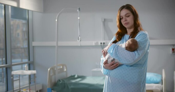 Caucasian mother holding her newborn baby after labor in ward at hospital