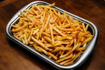 platter of french fries on a wooden table