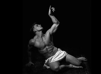 Man with muscular wet body. Art sexy man body. Athletic bodybuilder pose as statue.