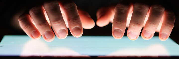 Male hands holding digital tablet at night close-up