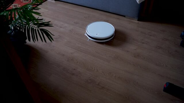 Robotic vacuum and mop cleaner cleans around furniture indoors and changes direction of moving automatically using it's sensor.