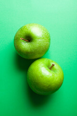 top view of 2 green apples on green background