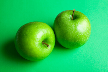 2 green apples on green background