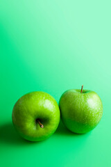 2 green apples on green background