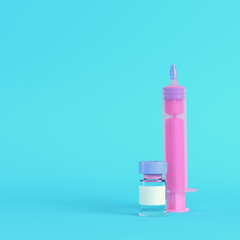Pink syringe with vaccine on bright blue background in pastel colors