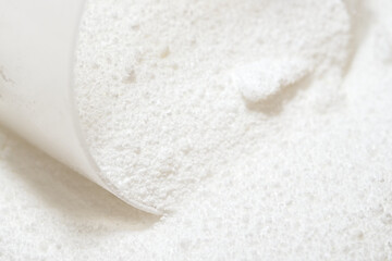 Laundry detergent powder for washing clothes. Bright white with scoop.