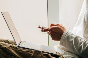closeup of hands with mobile phone and computer