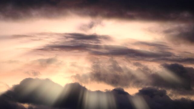 Timelapse of cloudy sky with light rays at sunset