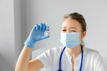 Doctor scientist with coronavirus vaccine in hand analyzing flask for clinical trial. Vaccine development and testing laboratory, selective focused.