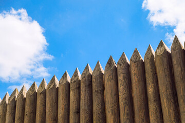 Ancient wooden fortification stockade fence of reconstructed fortress under blue sky