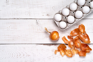 Easter eggs are colored with natural egg dye from fruits and vegetables, eggs are colored with onion husks on a white wooden table, copy the space