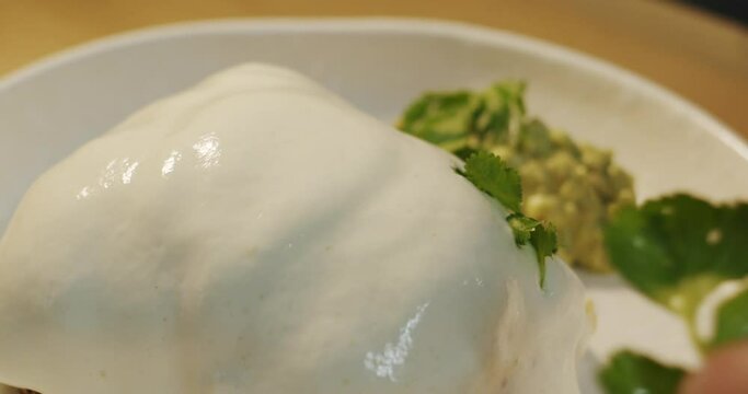 The hands of the chef add fresh parsley leaves to the delicate parmesan mousse on top of toast with omelet