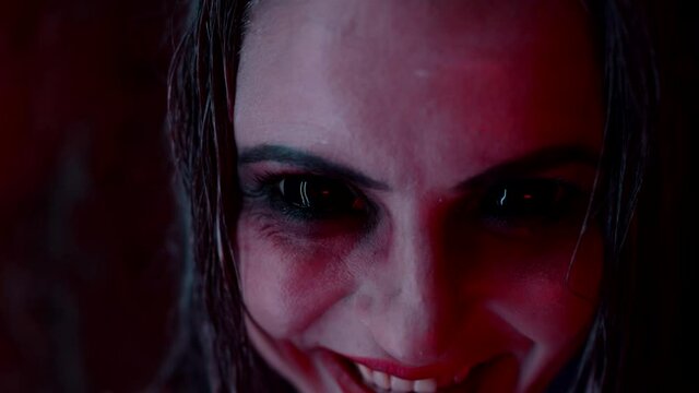 demoniac woman with large dark eyes and blood from mouth, looking at camera, possession by devil