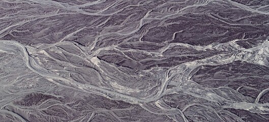 Dry riverbed in desert Nasca aerial view. Whimsical bizarre pattern of wavy lines on surface of the...