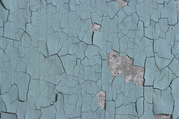 Fototapeta premium Peeling paint on the wall. Old concrete wall with cracked flaking paint. Weathered rough painted surface with patterns of cracks and peeling. High resolution texture for background and design. Closeup