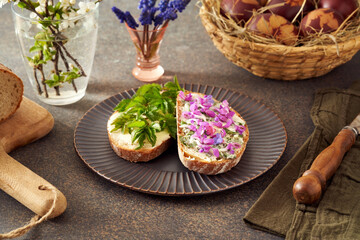Sourdough bread with butter and wild edible spring plants - goutweed leaves, purple dead-nettle and lungwort