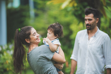 Fototapeta premium happy family with father and mother, and son child baby, childhood and parent in love together, smile kid and fun at home, enjoy outdoor life in summer