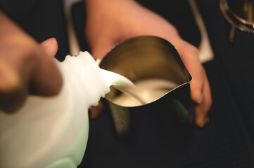 professional barista making latte art from coffee and milk, hand holding a cup of latte, espresso, cappuccino, drink in the morning breakfast