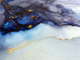 Abstract blue art with gold — fluid background with beautiful smudges and stains made with alcohol ink and golden pigment. Blue with violet texture resembles natural materials, watercolor or aquarelle