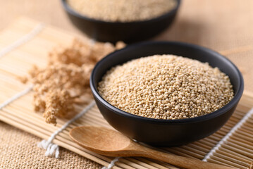 Brown quinoa seeds in a bowl with spoon, Edible seeds are high protein, Healthy food