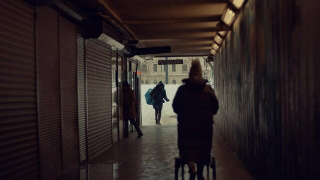 woman walks stroller under passage tunnel  slow motion