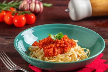 Fettuccine ao molho de tomate, decorado com folhas de manjericão
