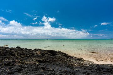 Incredible emerald waters, dark cracked limestone typical of the coast in the foreground. Access through the Ibaruma Sabichi cave. Northwest of Ishigaki.