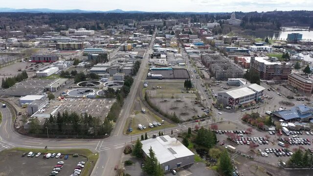 Cinematic drone trucking footage of the springtime cherry blossoms at the Washington State Capitol Building and Campus, Capitol Lake, with a panoramic view of Historic District in Olympia, Washington