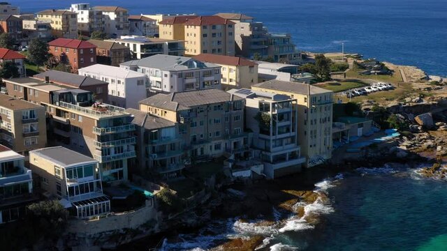 Accommodation Buildings On Elevated Coast With Ocean Waves Hitting The Rocks. Ben Buckler Suburb In NSW, Australia. aerial drone