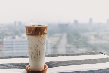 Iced coffee milk served in a tall plastic cup.