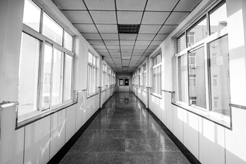 Sunlight shines on an empty hospital corridor in a monochrome photo