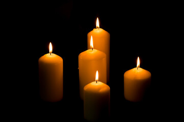 The candle flame is approaching the dark background in the night.