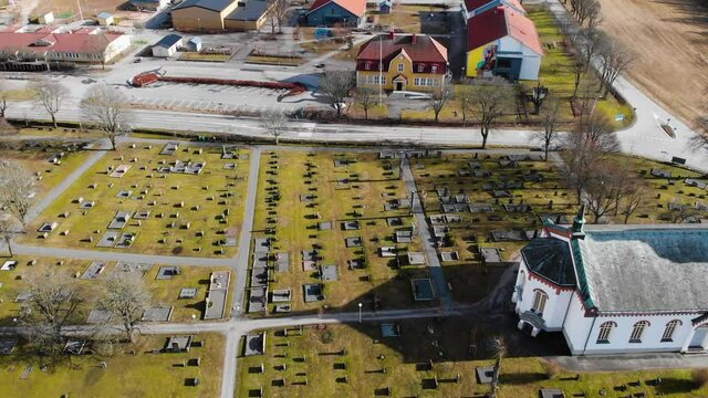 Aerial View Of Public Library And School Near Cemetery And Bjorketorp Church In Ravlanda Town, Harryda, Sweden. drone pullback (ascending)