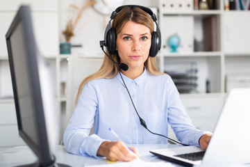 positive woman working with headphones on her laptop in white room.