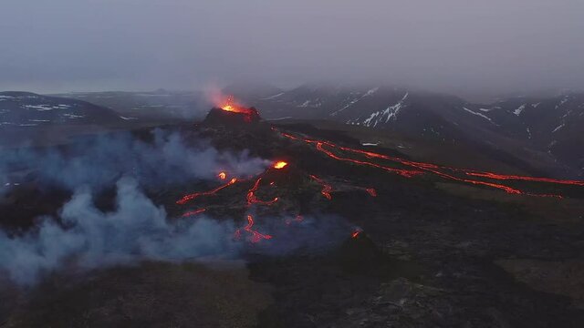 Aerial view towards smoking lava craters, at a Volcano basin - establishing, drone shot