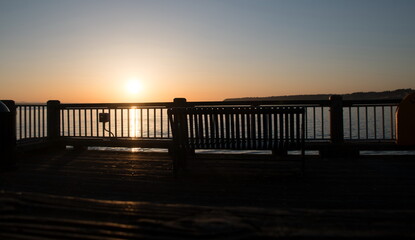 Fototapeta na wymiar Watching sunset thru rail of Jorgensen Pier in Semiahmoo Bay