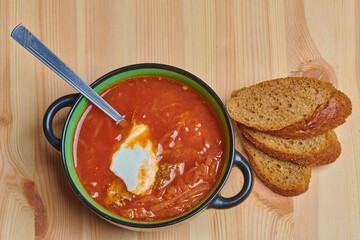 a bowl of borscht and three slices of bread