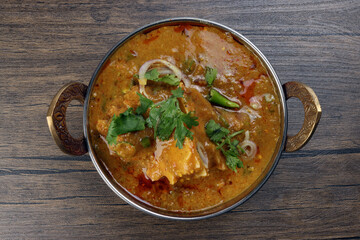 Haleem stew wheat barley lentils mutton goat chicken beef meat bone spice served in a copper brass pot over rustic wood background